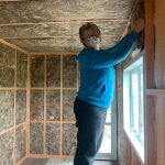 Gerry installing glasswool batts for extra insulation.